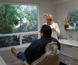 Dental assistant working with patient in operatory room at Dr. Falvey's practice
