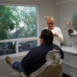 Dental assistant working with patient in operatory room at Dr. Falvey's practice