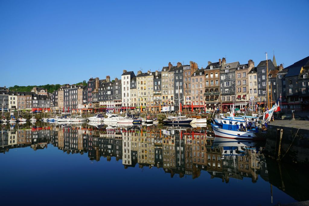 Docked boats and houses reflected in water