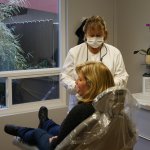 Dental assistant working with patient in operatory room at Dr. Falvey's practice