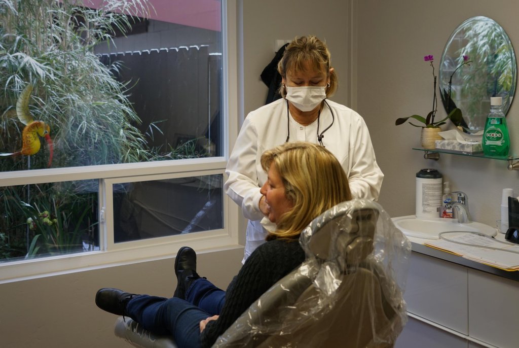 Dental assistant working with patient in operatory room at Dr. Falvey's practice