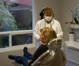 Dental assistant working with patient in operatory room at Dr. Falvey's practice