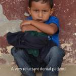 A child sitting with their arms crossed and scowling during a Honduras Mission trip